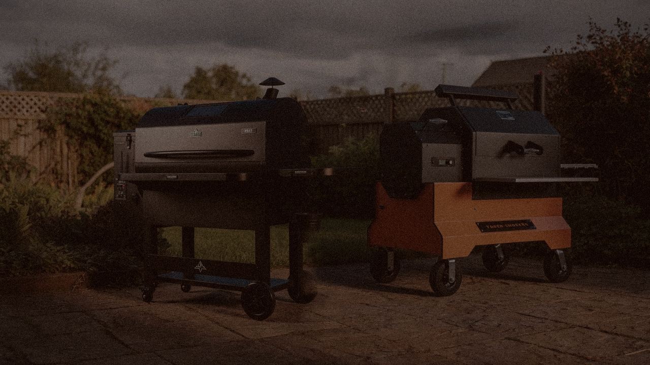 Green Mountain Grills Peak and Yoder Smokers YS640s at night with smoke, wood pellet grills on a dark patio