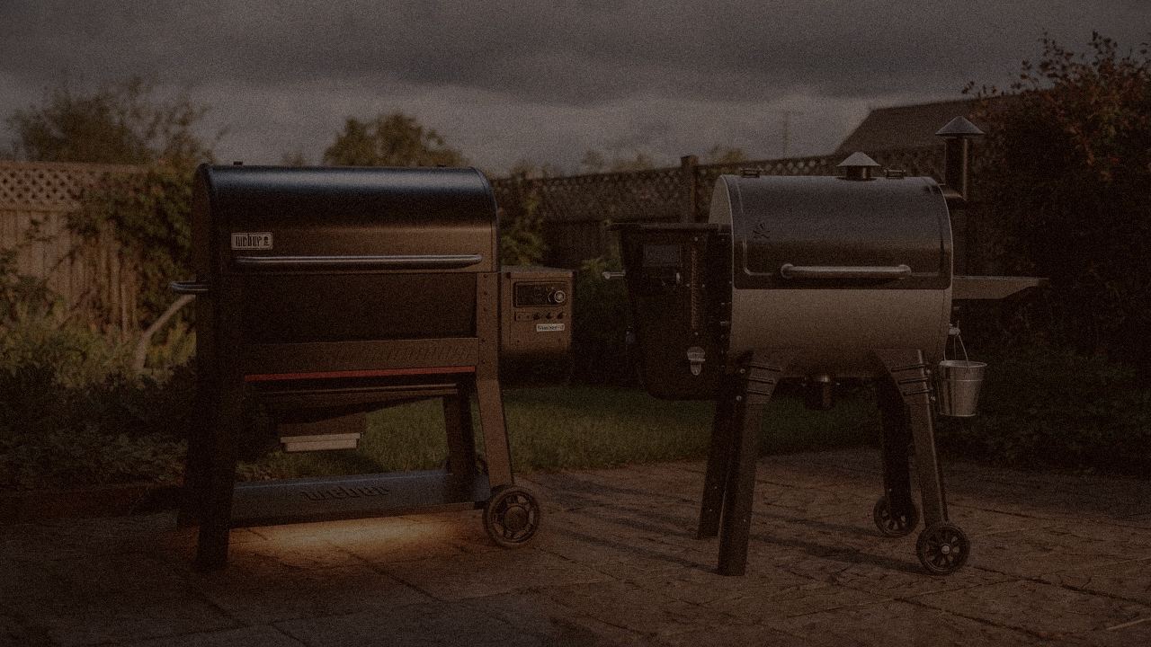 Weber Searwood XL 600 and Camp Chef Woodwind WiFi 24 at night with smoke, wood pellet grills on a dark patio